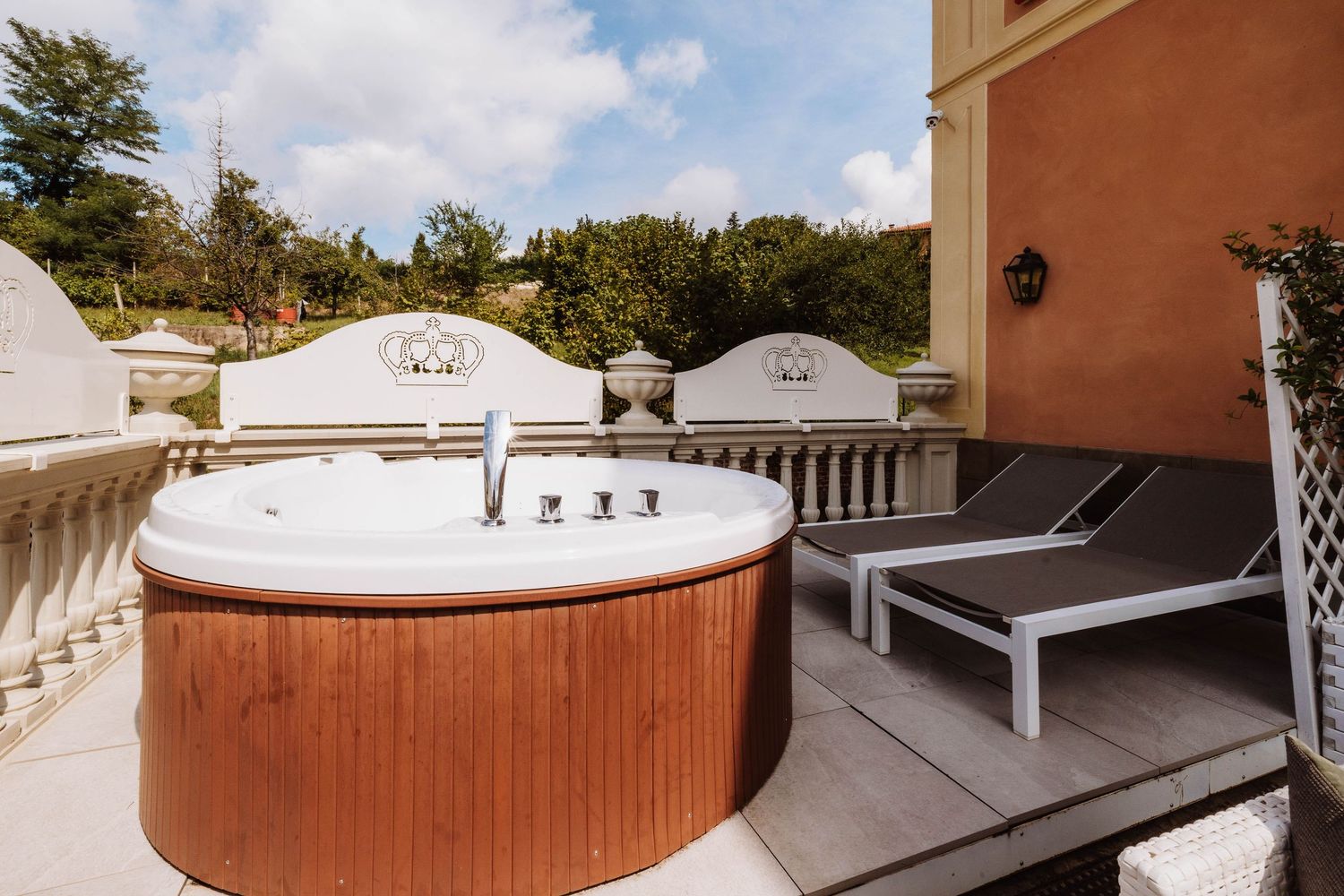 A luxurious outdoor hot tub on a wooden deck with mountain views and surrounding trees creates a serene spa setting.