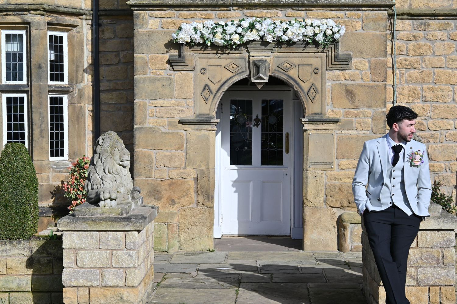 Elegant stone building facade with multiple white-framed windows and decorative architectural details.