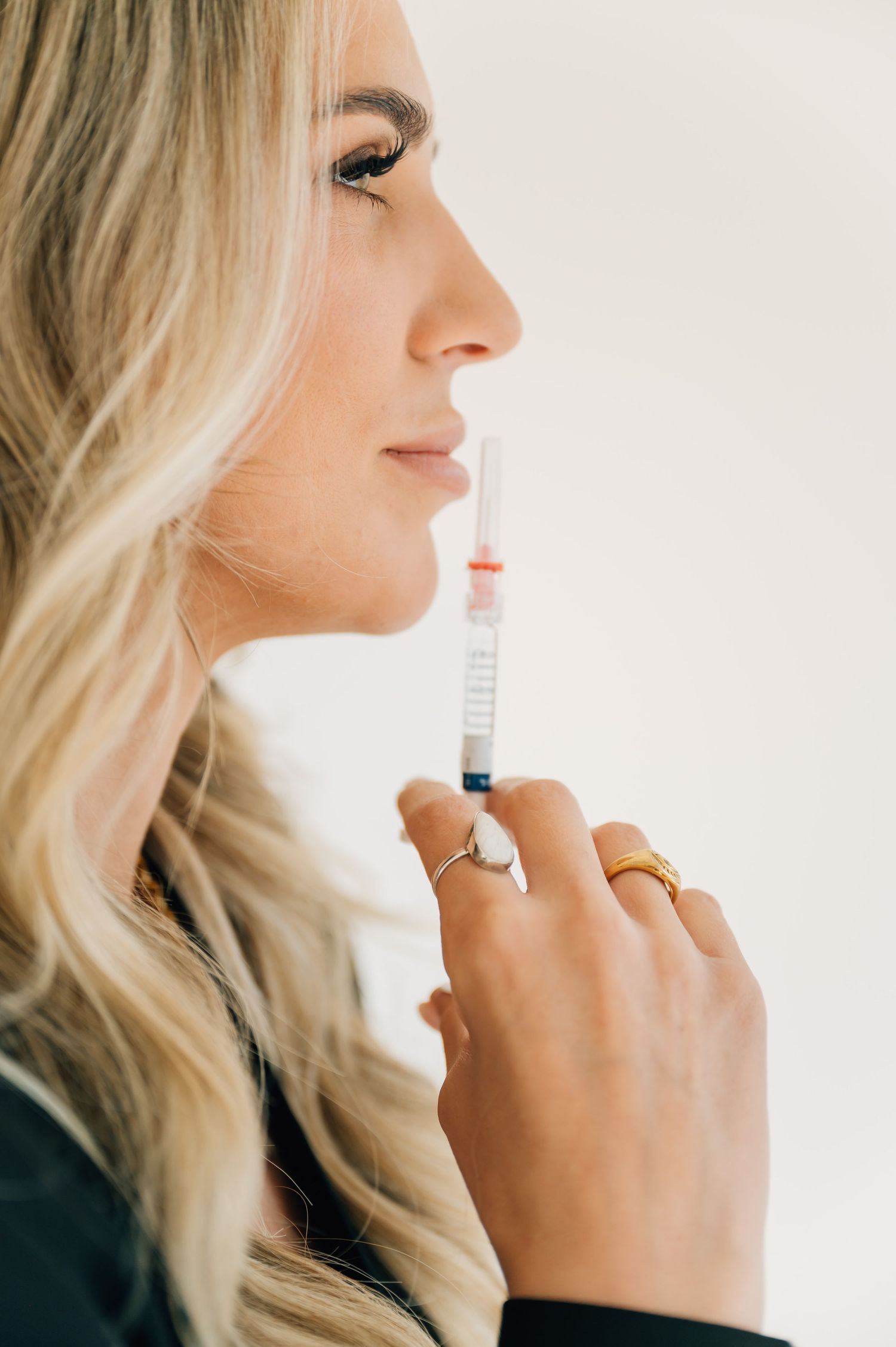 A series of profile shots showing someone applying lip gloss or lip treatment in natural lighting.