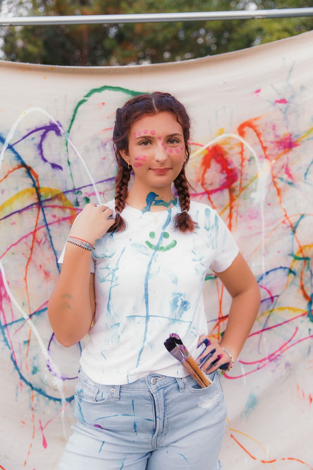 A collection of shots featuring someone in a white top and jeans posing by a graffiti-covered white backdrop.