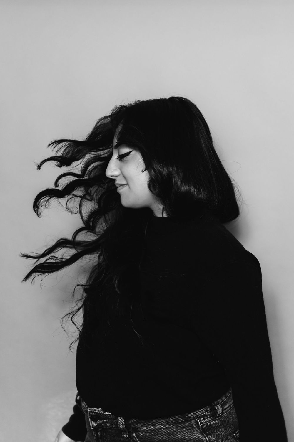 A dramatic black and white photo series showing silhouetted hair movement against a light background.
