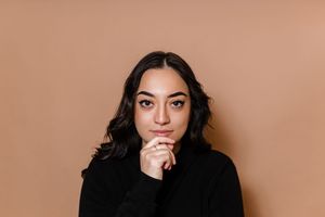 Person with long dark hair poses against neutral background in multiple artistic portrait shots.
