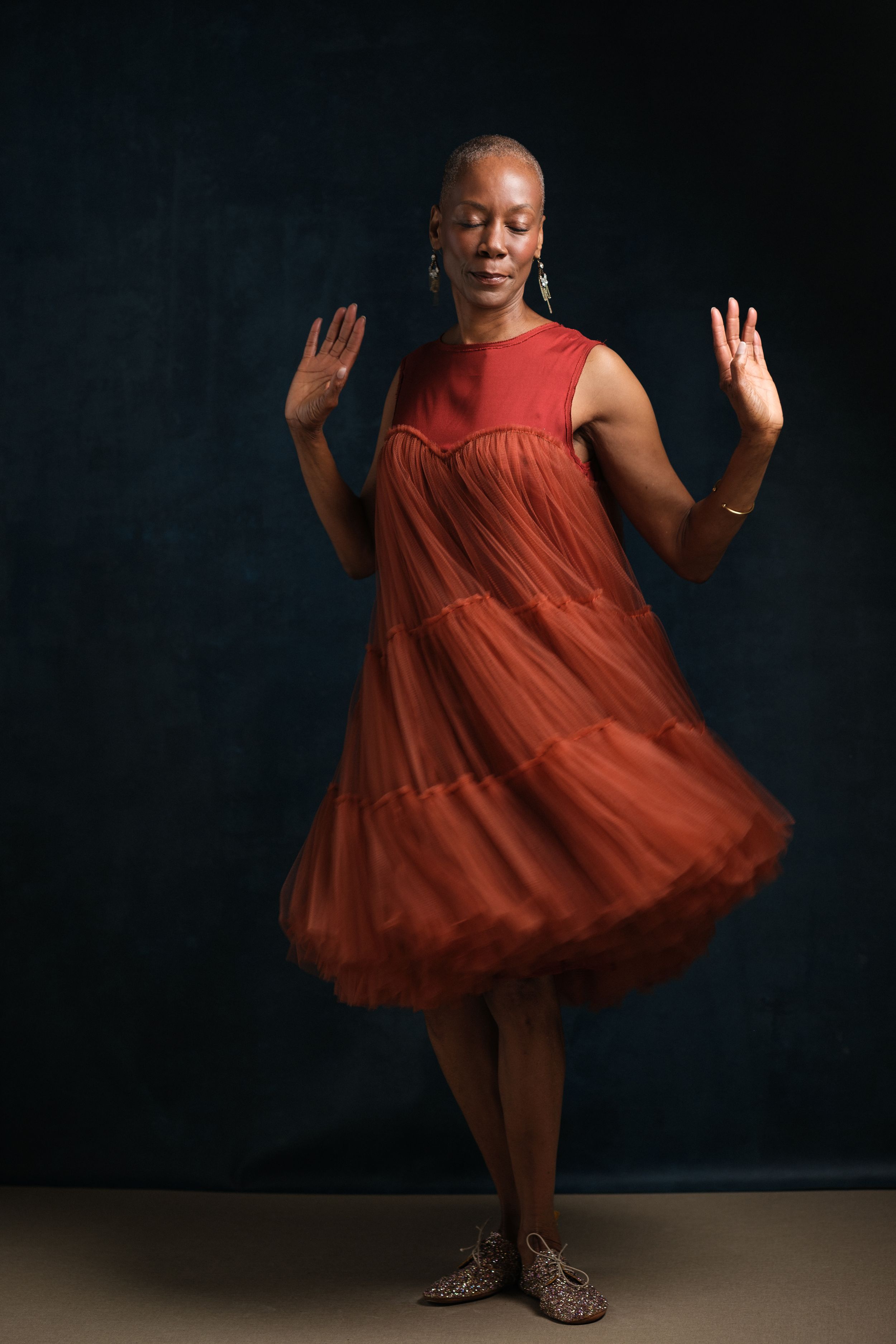 Expressive dance pose in flowing red dress shows movement and joy.