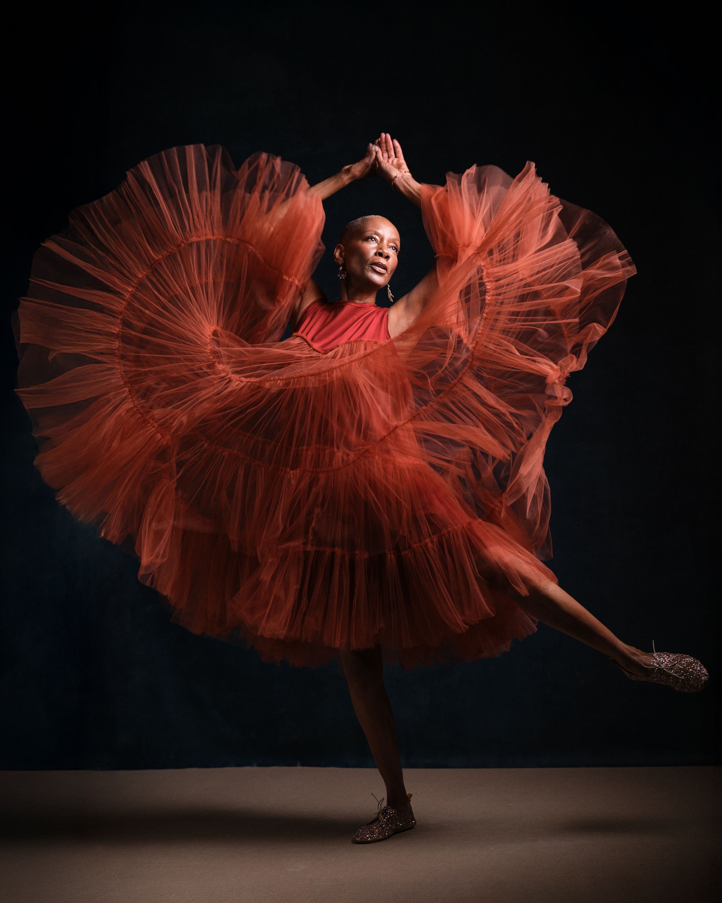 Graceful dance movement captured with flowing red dress creating dramatic shapes in motion.