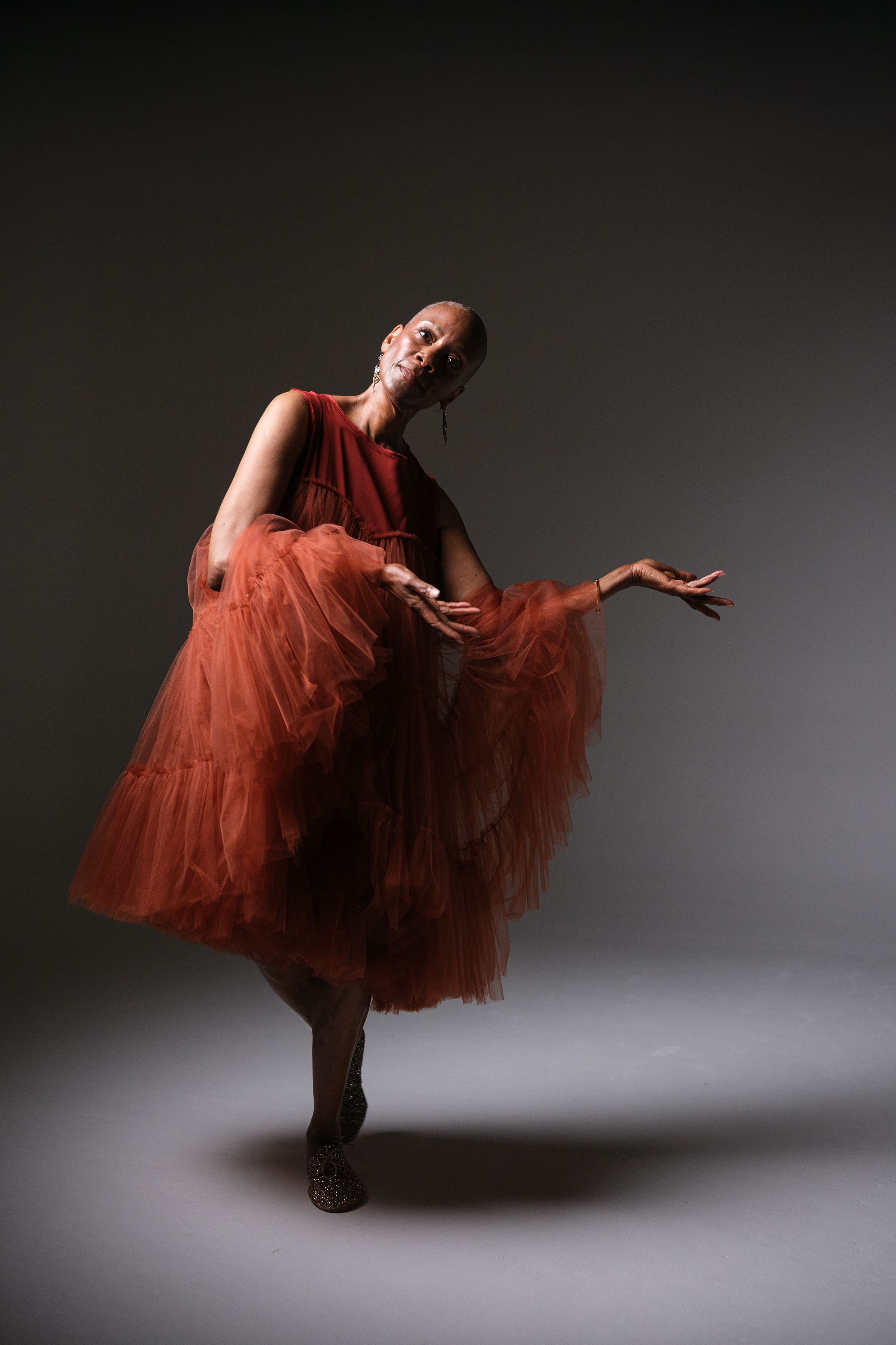 Artistic dance sequence showing movement in a billowing red dress against dark background.
