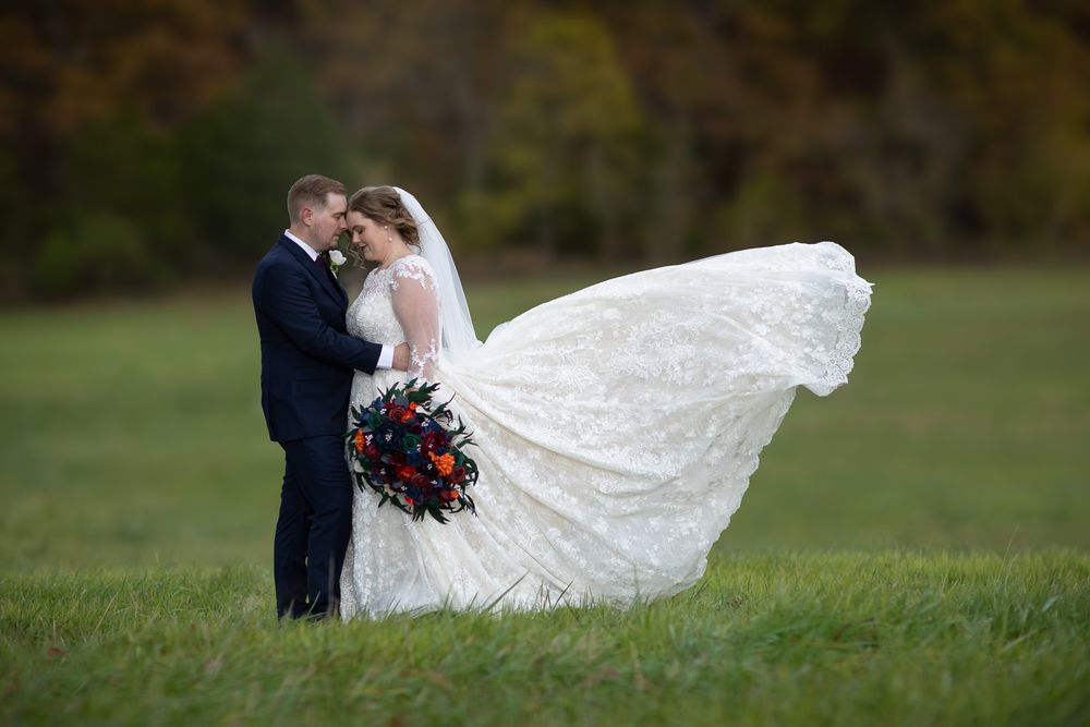 Bride and groom portrait in field during wedding photos with flowing dress by Joplin wedding photographer