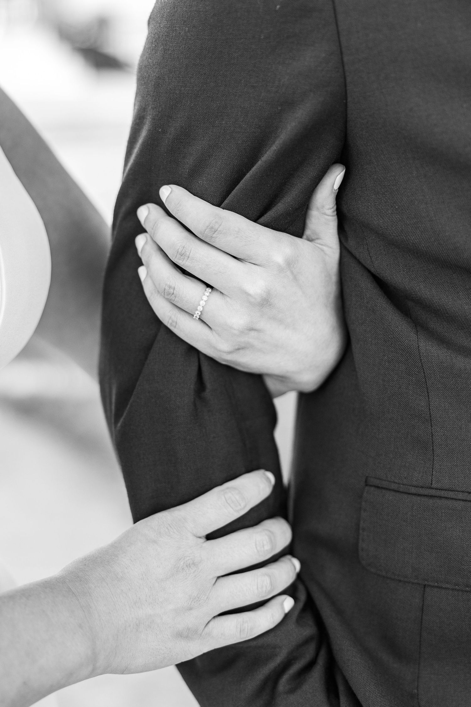 Black and white close-up shots of hands gently placed on formal attire.