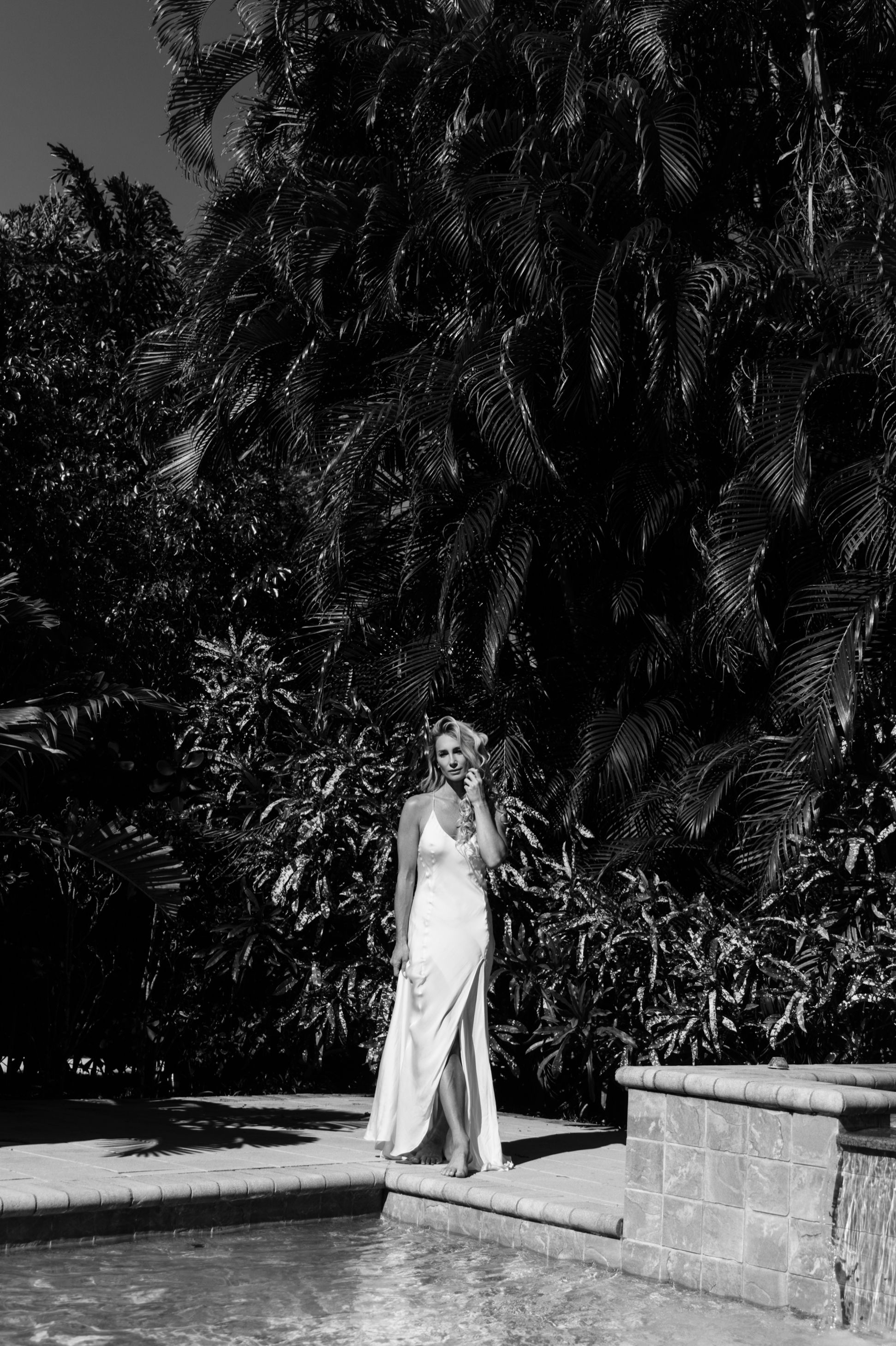 Fine art black and white editorial portrait photographed poolside in luxury Jupiter Florida tropical setting.