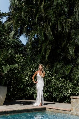 Luxury outdoor portrait in silk gown photographed beside tropical poolside setting in Jupiter Florida.