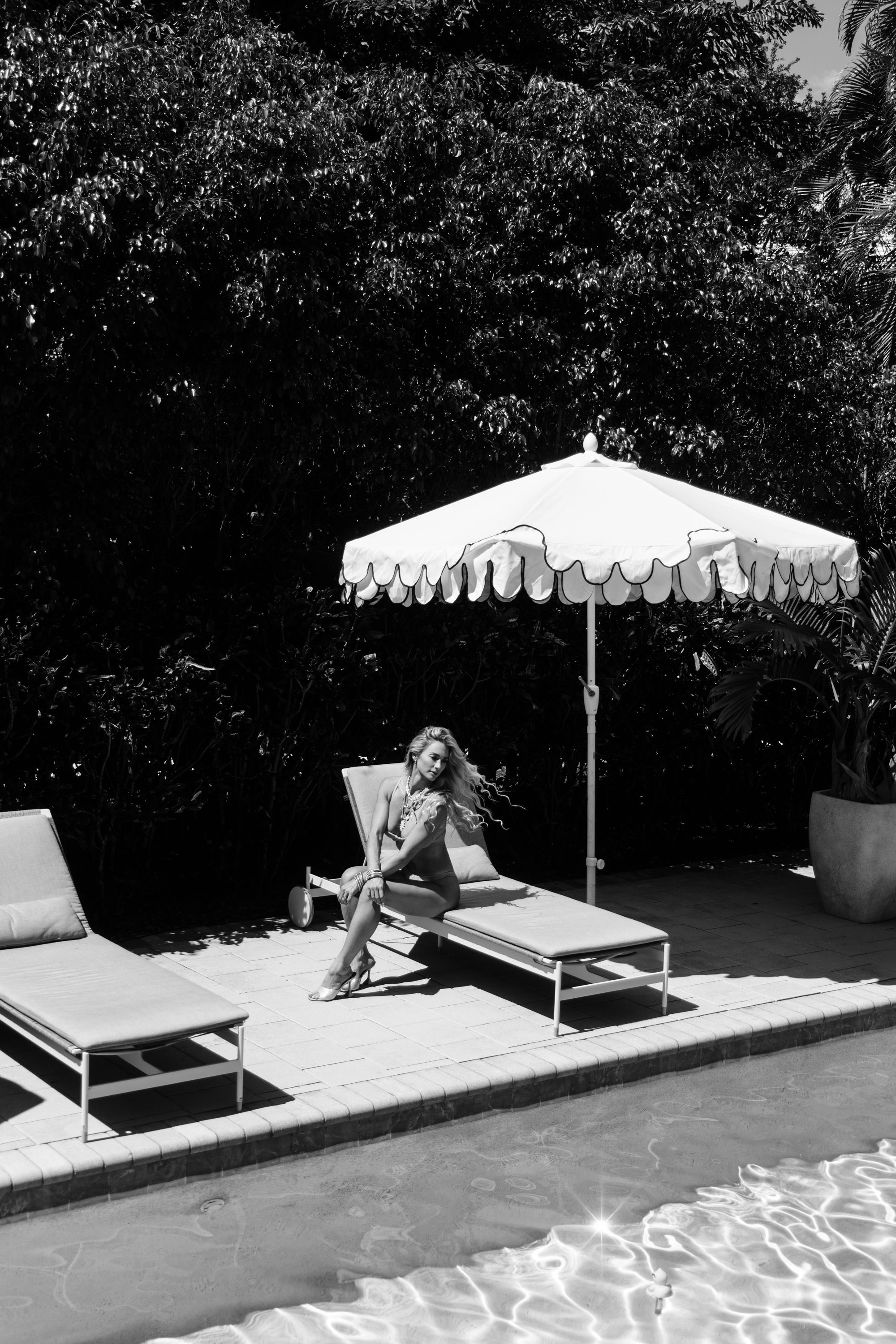 Black and white luxury poolside lifestyle portrait photographed in upscale Jupiter Florida tropical location.