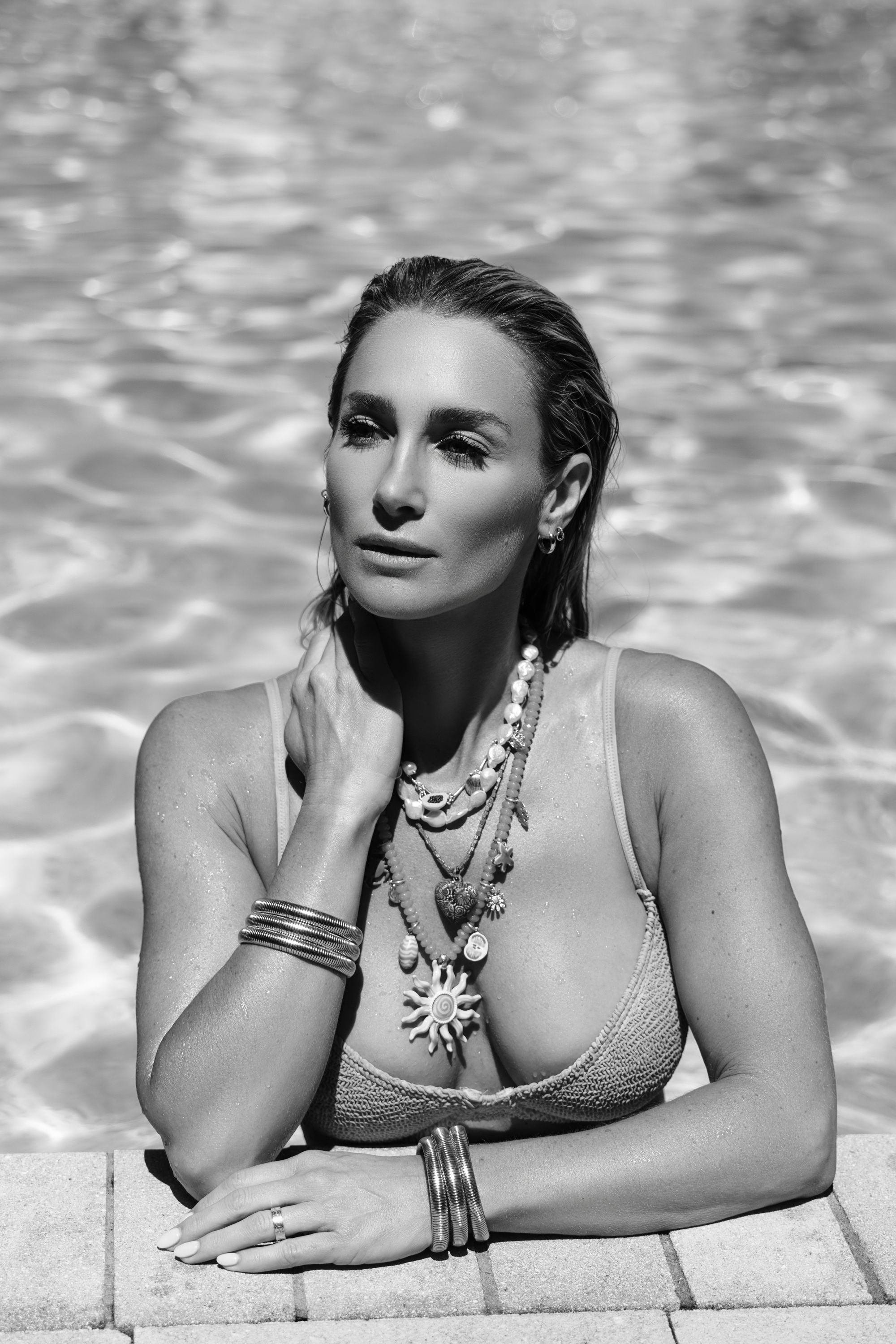 Black and white luxury swimwear portrait photographed poolside in upscale Jupiter Florida editorial setting.