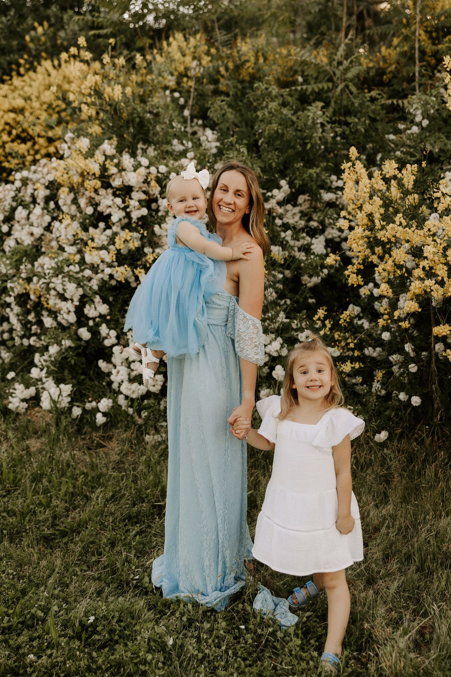 A tender moment captured in a garden with yellow and white flowers as backdrop.