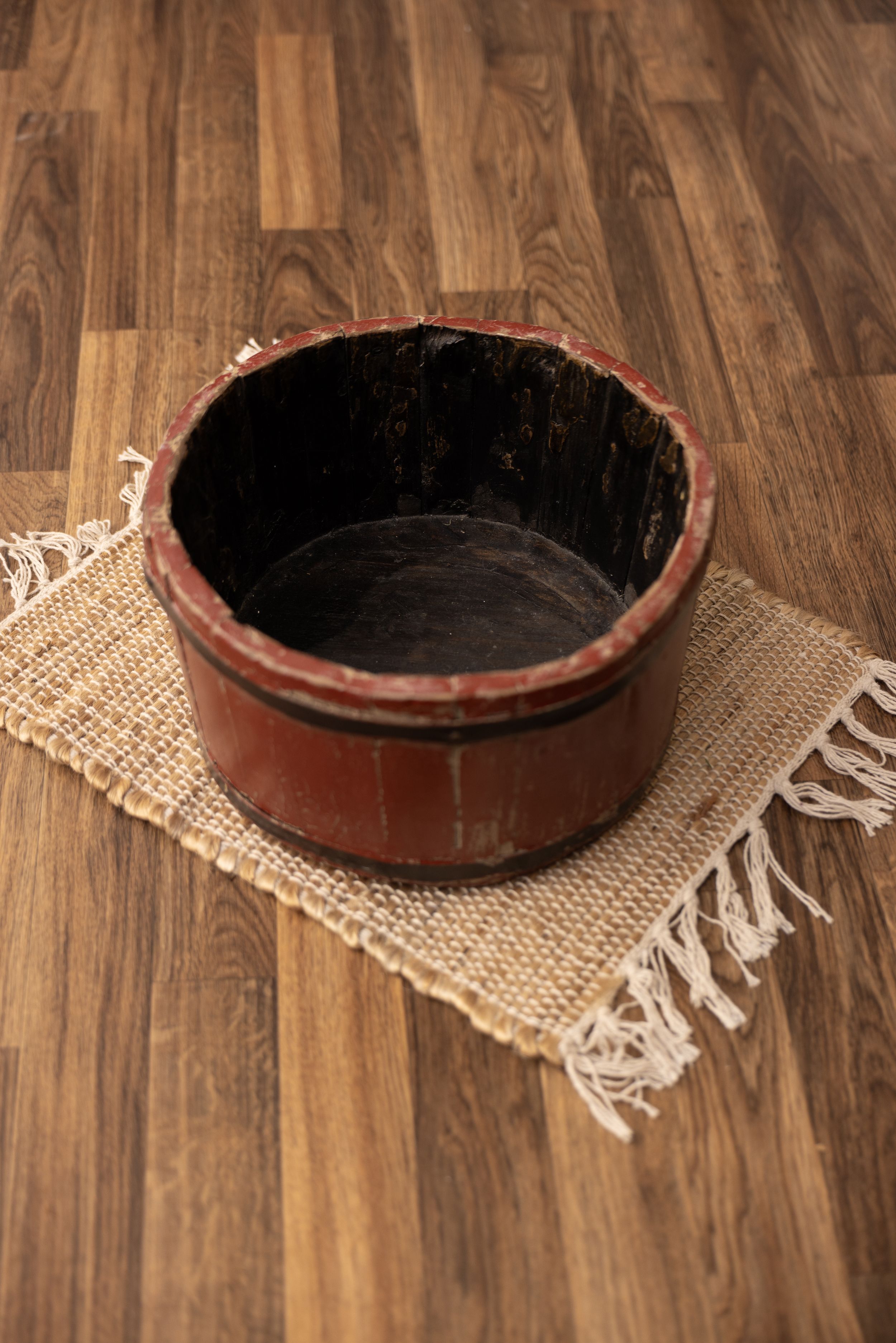 Short red wooden bucket with black interior