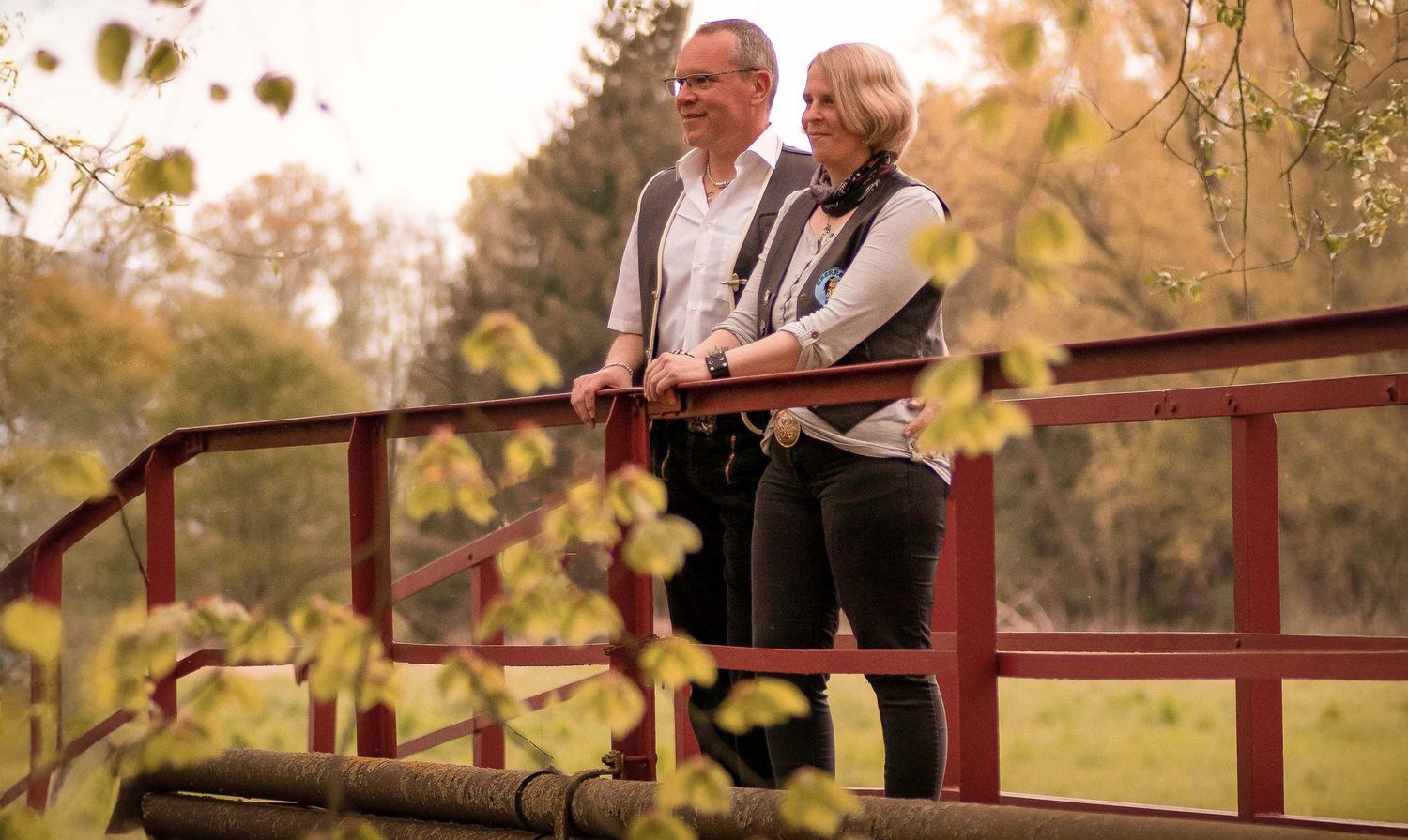 Natürliches Portraitfoto eines Paares auf einer Brücke in ländlicher Umgebung