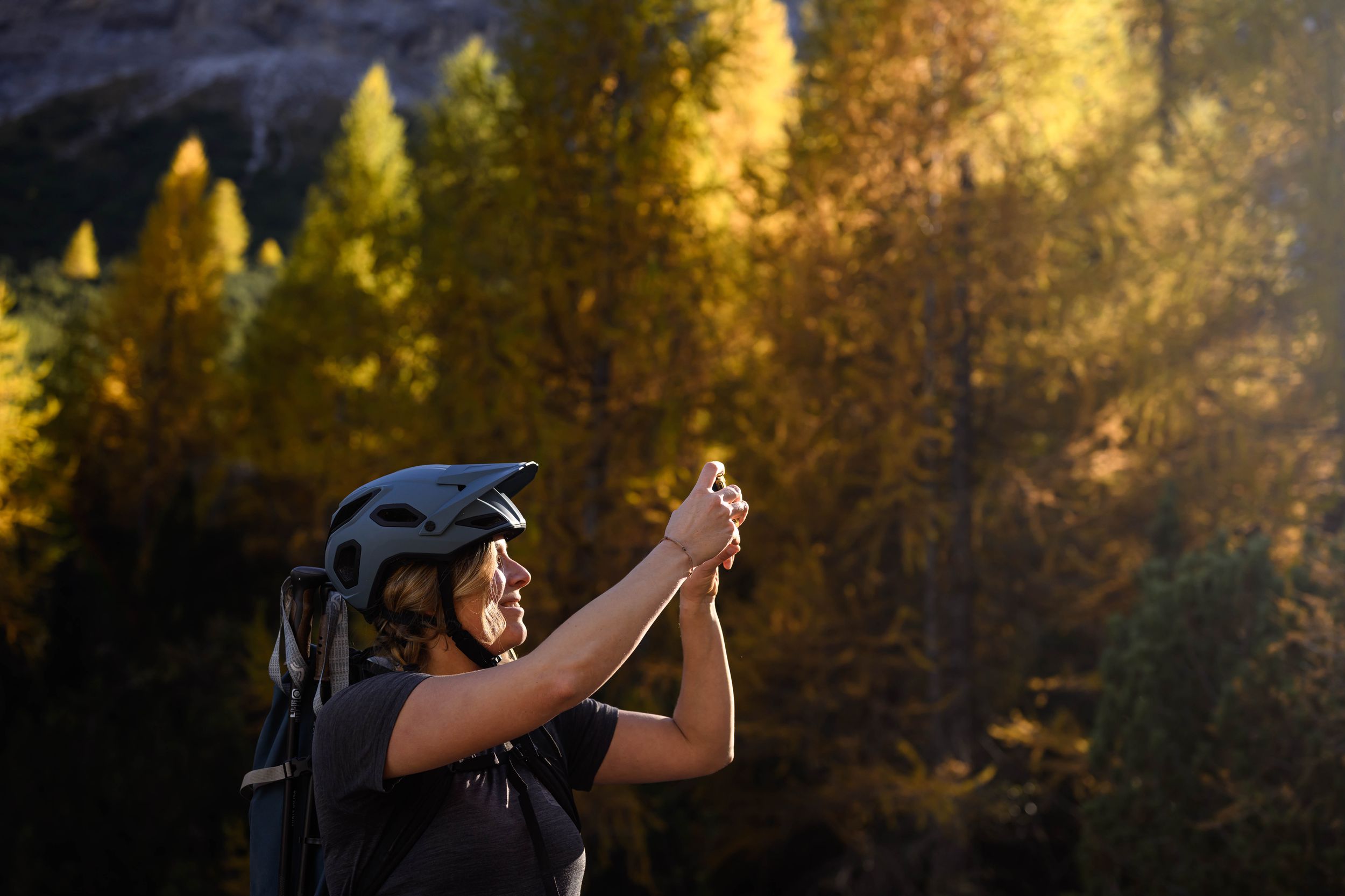 A couple dances together in a golden forest setting during sunset, creating a romantic silhouette against the trees.