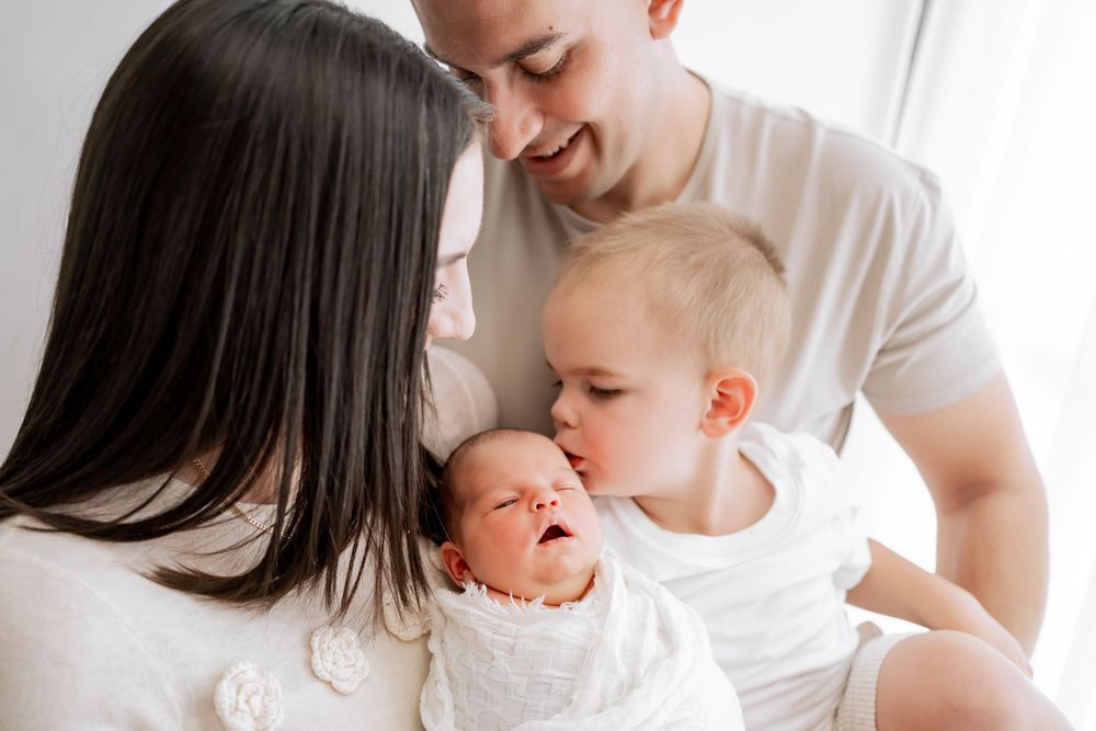 Loving family moment as parents share tender interaction with their children at home.