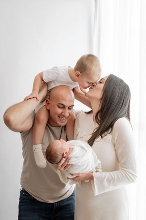 A loving family shares a tender moment together against a white background, creating a heartwarming portrait.