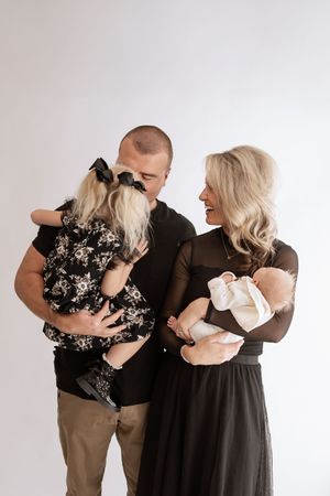 Three progressive photos show a couple in black and white outfits embracing and sharing tender moments together.