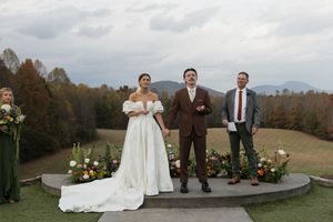 Wedding ceremony setup on an outdoor deck with mountain views and floral arrangements.