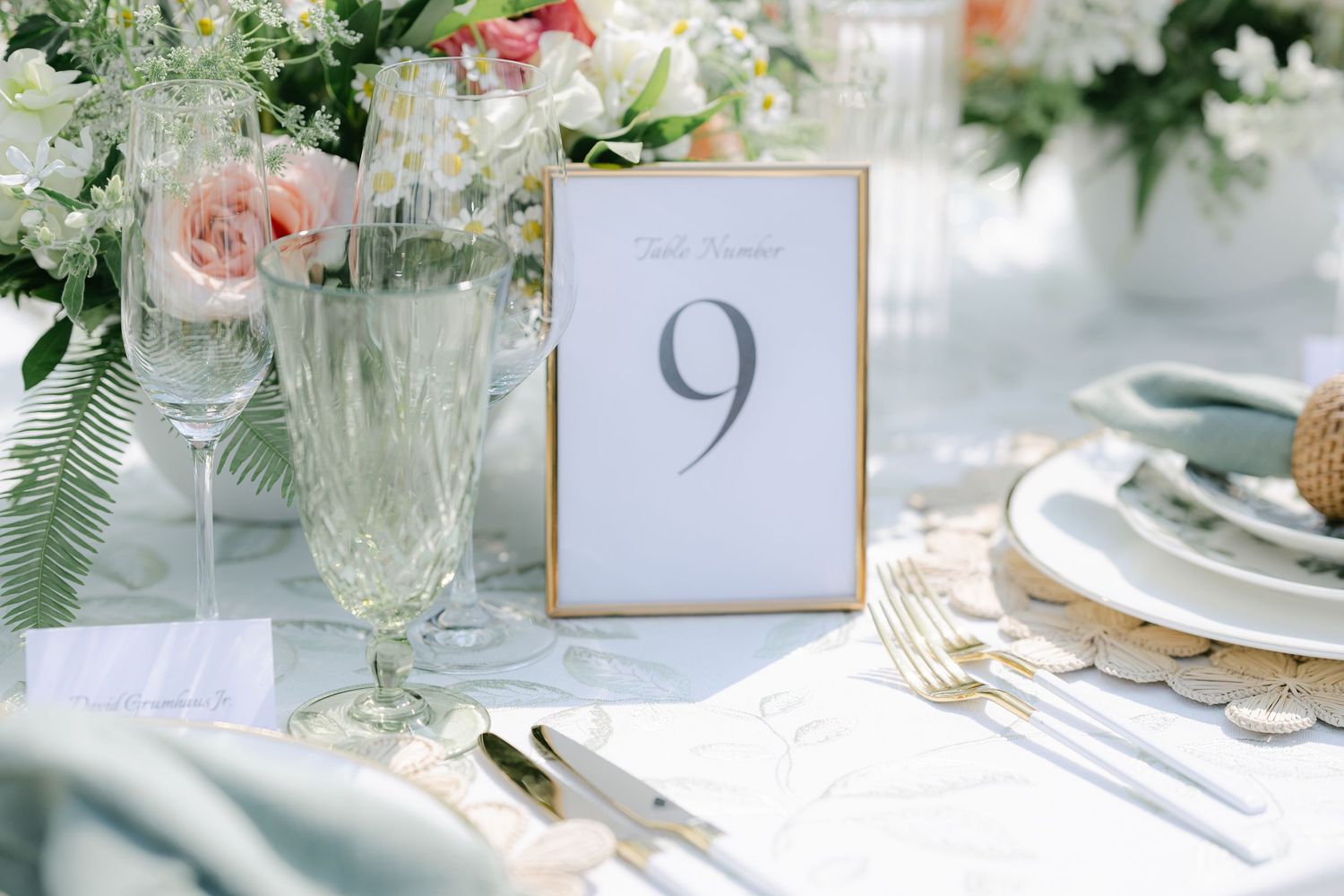 Elegant table setting with pink roses, crystal glassware, gold cutlery and table numbers in gold frames. - Elawa Farm