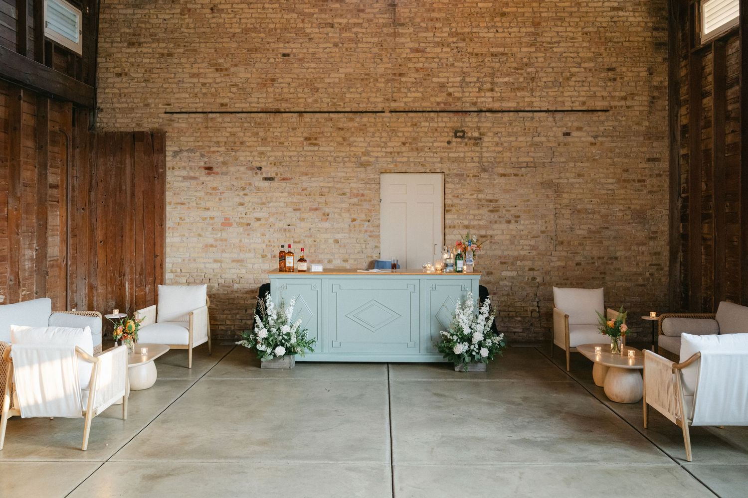 Panoramic view of an empty industrial warehouse interior with exposed brick walls and concrete floors. - Elawa Farm