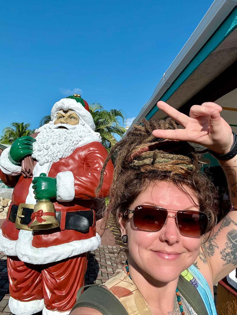 A series of selfies taken at a tropical resort with palm trees and sunglasses against a bright blue sky.