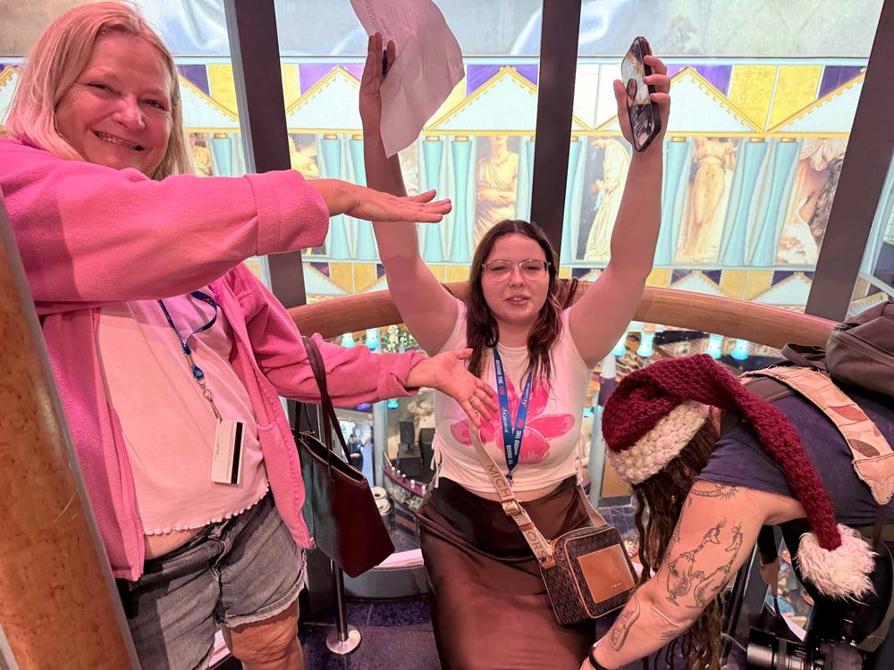 People in pink jackets dance and move together in a group exercise or dance class setting.