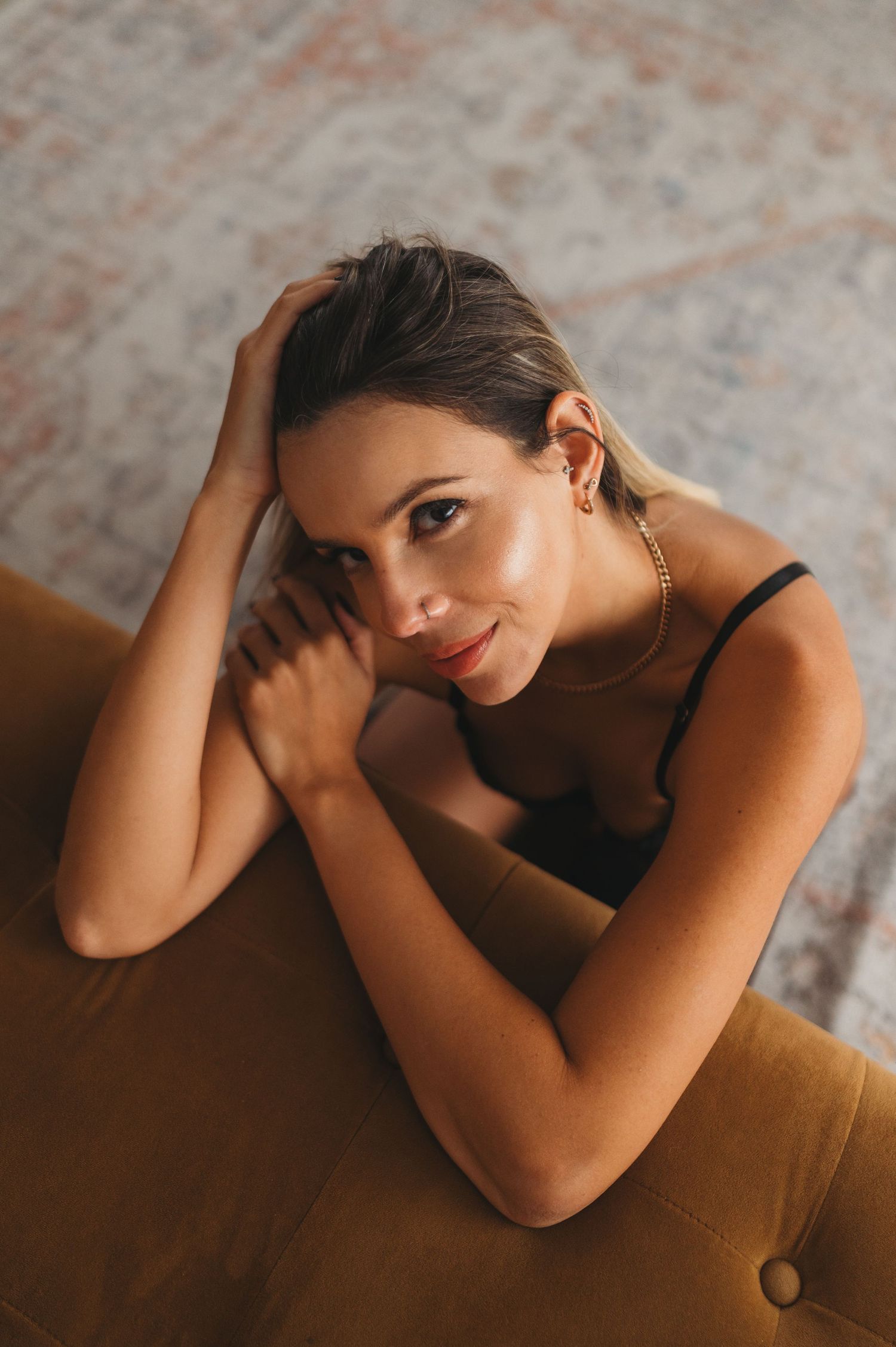 Intimate portrait session on brown furniture with moody lighting and dark aesthetic.