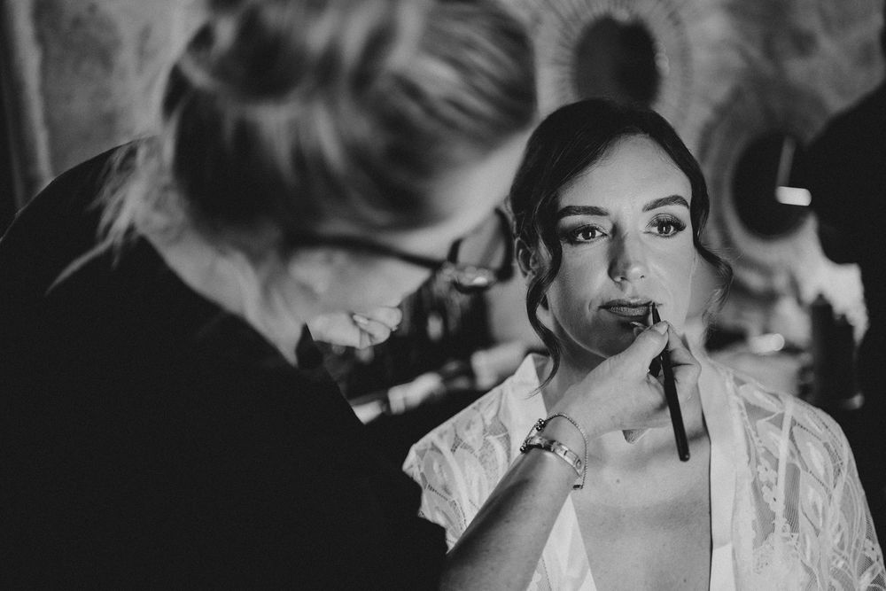 A collection of black and white wedding photos showing intimate moments between couples and wedding party preparations.