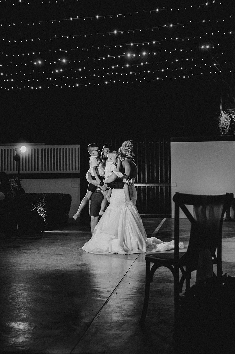 A black and white artistic wedding photo series showing brides in elegant gowns posing in a dimly lit venue.