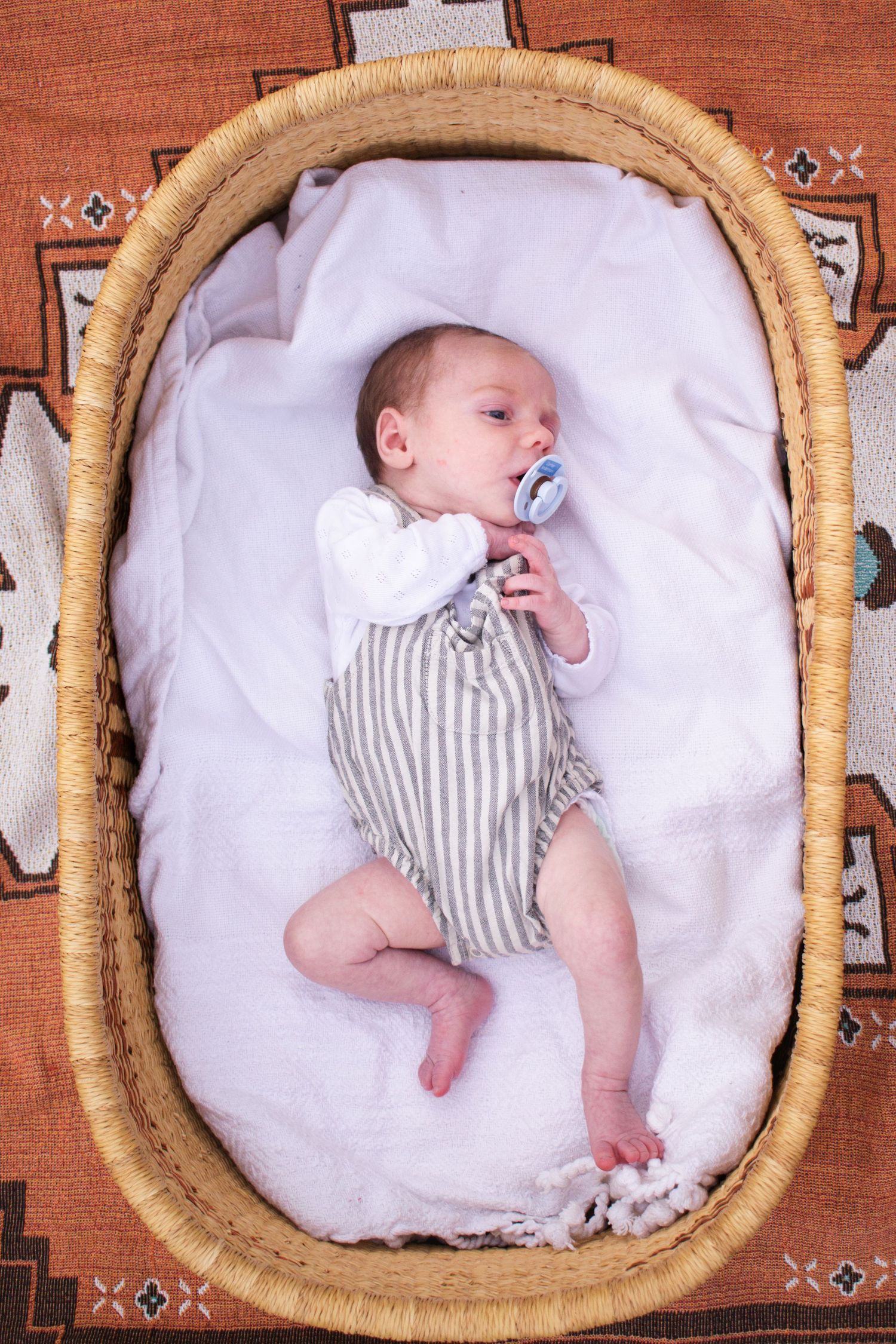 Newborn stretching out in Moses basket during a country newborn photoshoot Maitland NSW