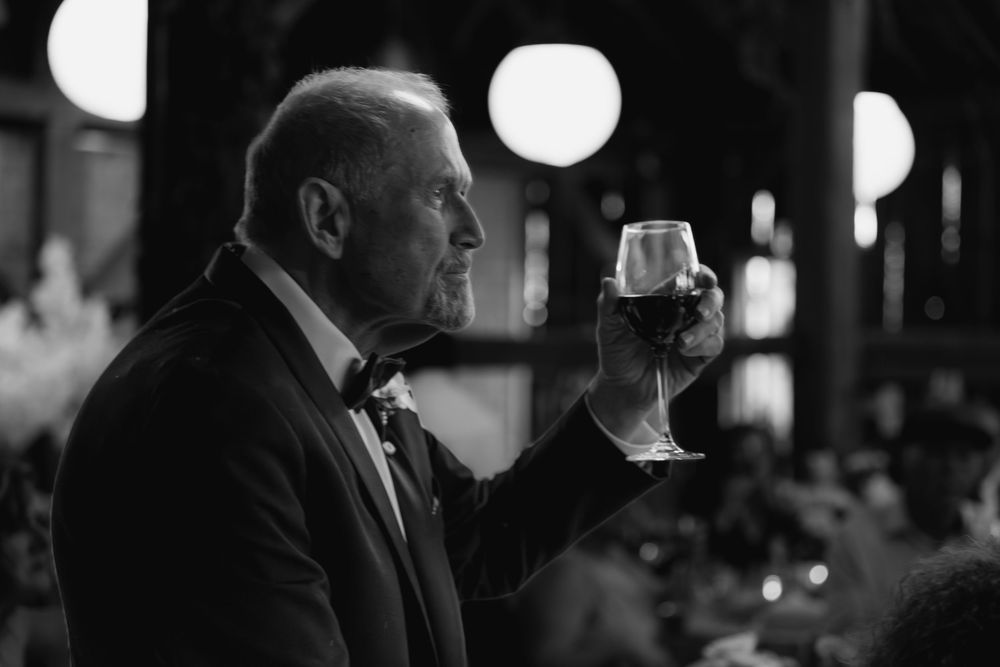 People in formal attire enjoy drinks and conversation at an elegant evening gathering.