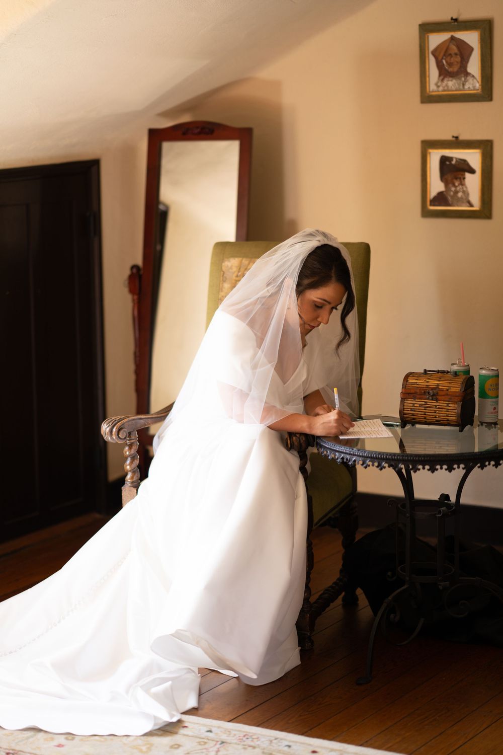 A bride in a flowing white dress and veil kneels gracefully on a wooden floor in a series of artistic poses.
