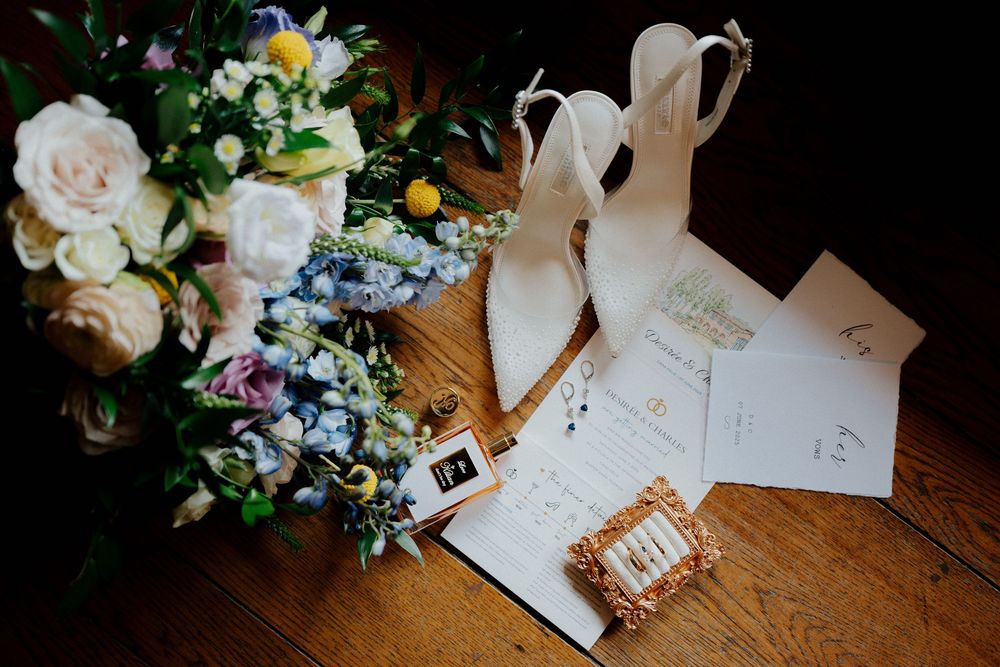Wedding invitations and floral arrangements with roses and delicate blooms displayed on a wooden surface.