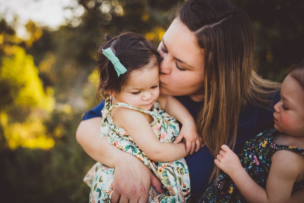 A tender family moment captured in warm golden sunlight during an outdoor autumn photoshoot.