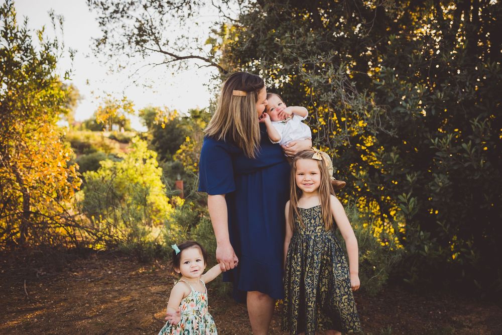 A series of intimate family portraits set against a backdrop of trees in glowing evening light.