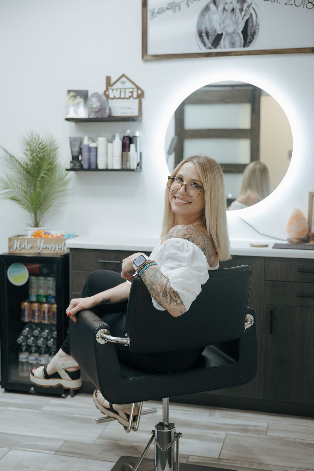 A series of four photos showing someone relaxing and spinning in a black salon chair in a modern home salon setting.