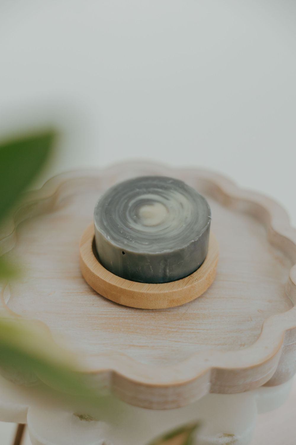 Close-up sequence showing a circular magnet being placed into a decorative wooden flower-shaped holder.
