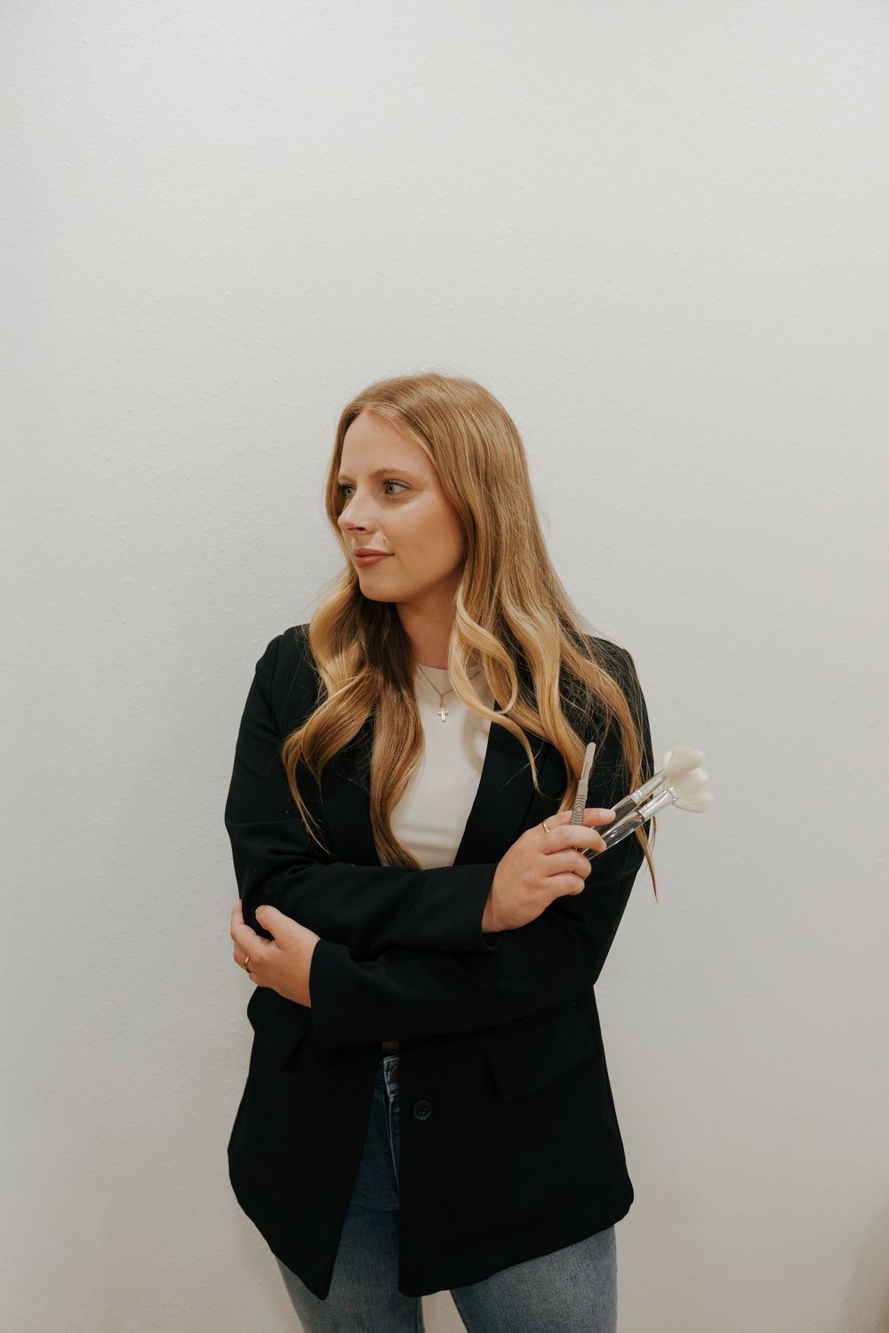 A sequence of photos showing a person in a black blazer and light hair making dramatic gestures against a white wall.