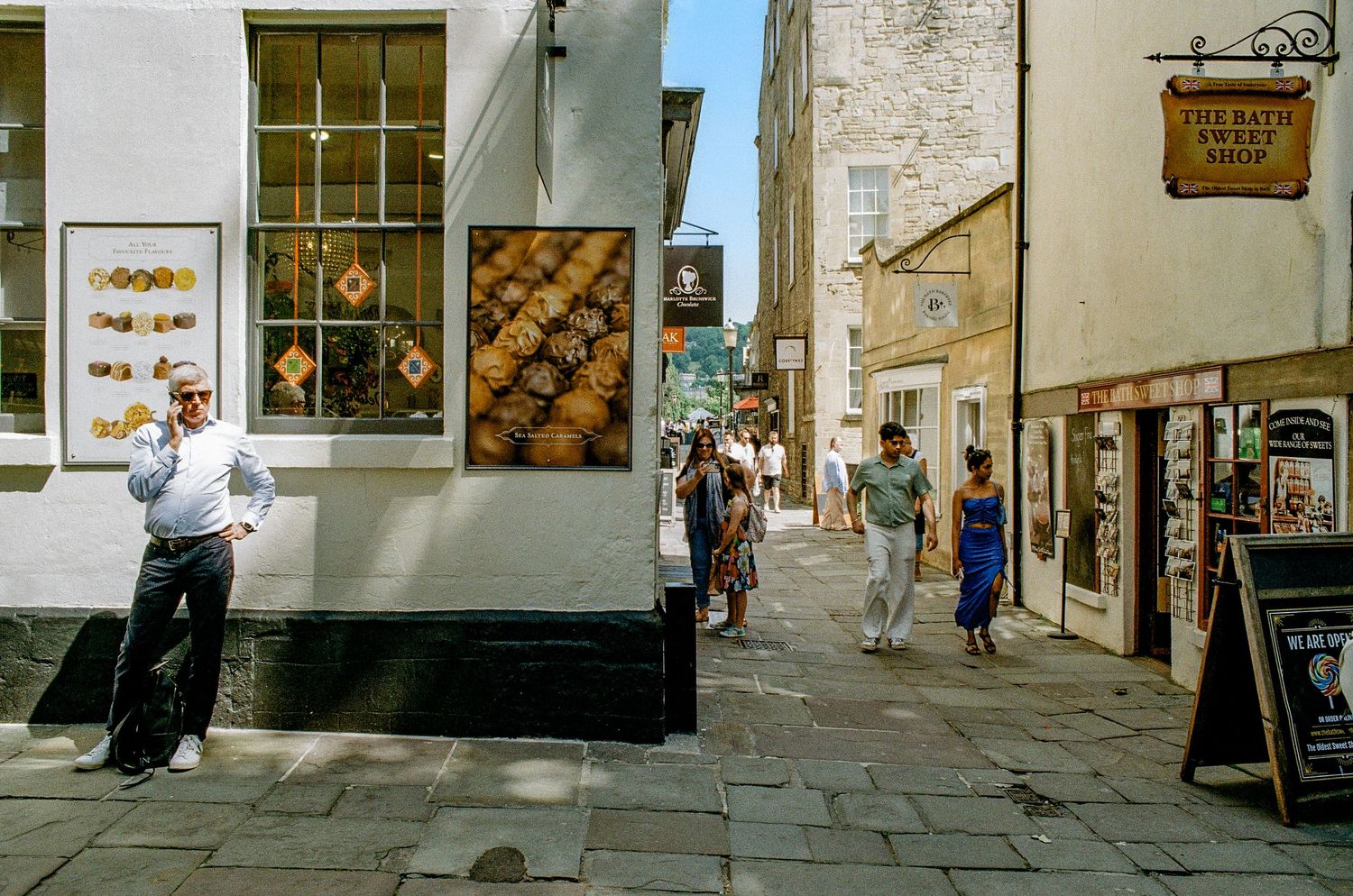 Charming street scene in Bath with bakery windows and historic stone buildings.