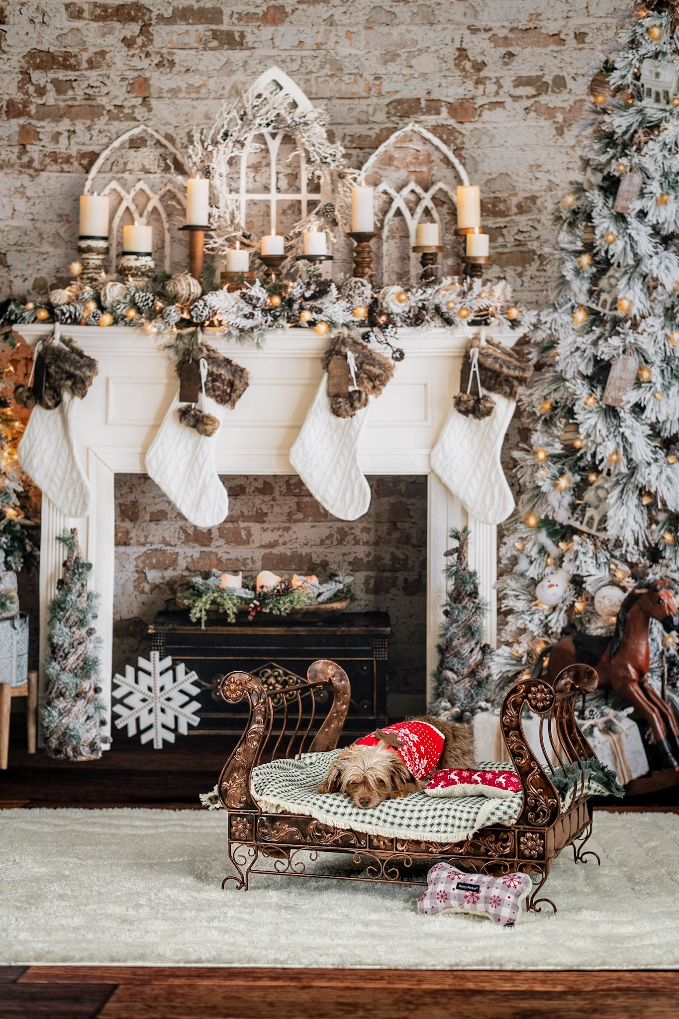 Elegant Christmas mantel with gothic arches, white stockings and holiday decorations against brick wall.
