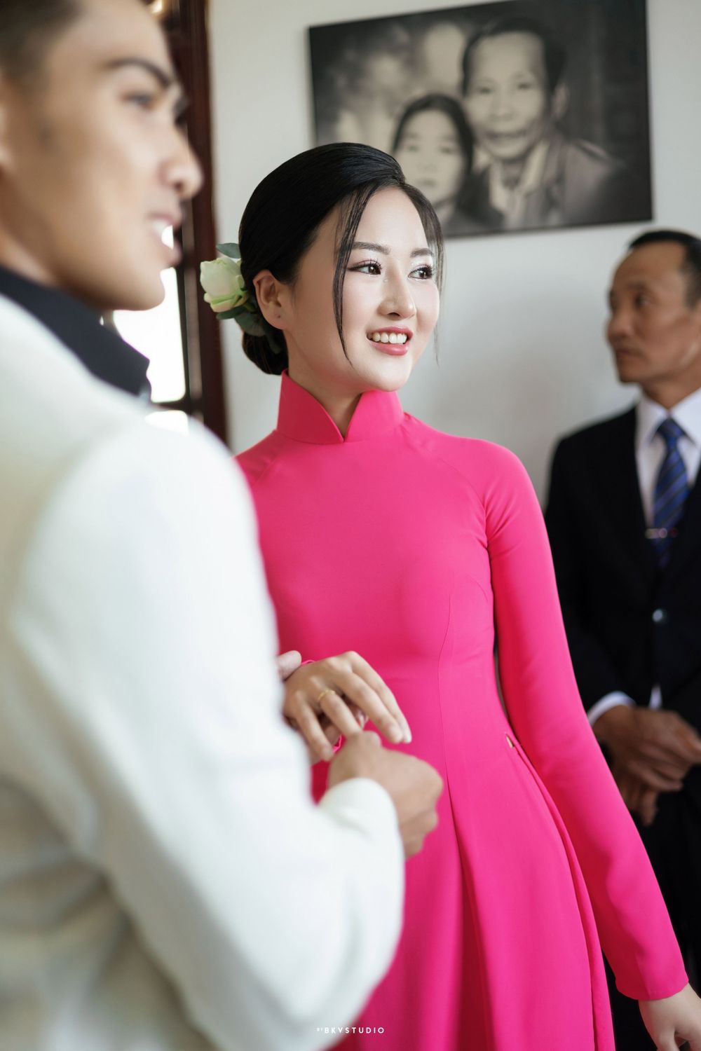 Traditional wedding ceremony with couple wearing formal attire in pink and white.