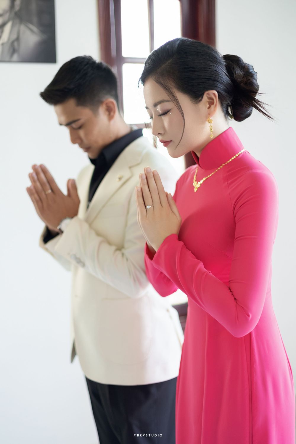Couple in traditional dress praying together during a wedding ceremony.
