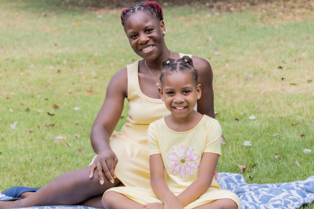 Two people enjoying quality time together while relaxing on a picnic blanket in the park.