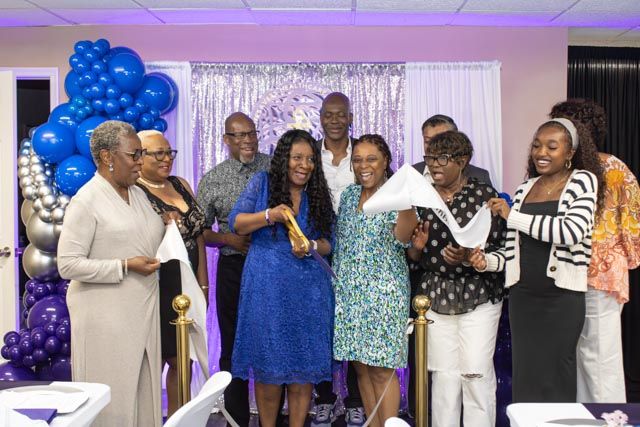 Group of people celebrating at a formal event with blue and silver balloon decorations in a decorated hall.