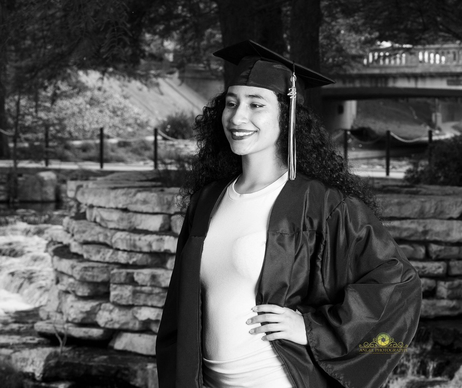 Black and white graduation portrait taken against a stone wall backdrop.