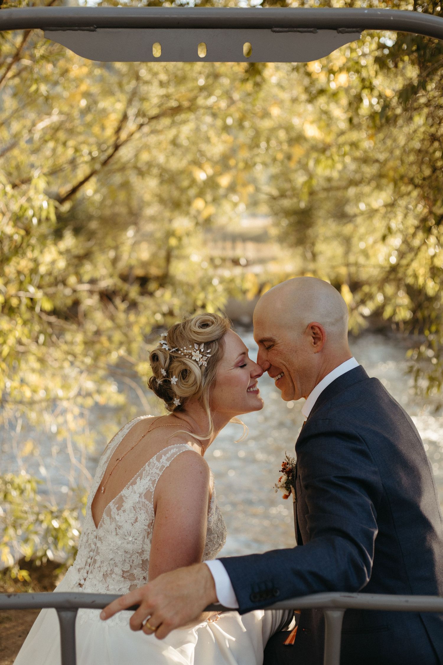 A romantic moment between a couple on their wedding day surrounded by golden autumn foliage.