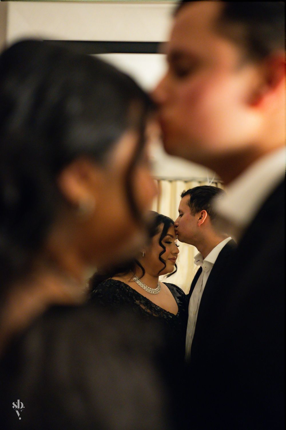 Artful wedding photo showing couples in intimate dance poses captured with soft focus and romantic lighting.