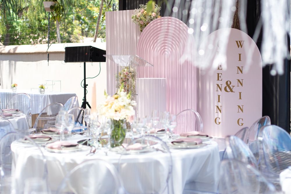 Pink and white wedding reception table with art deco inspired decor and floral arrangements.