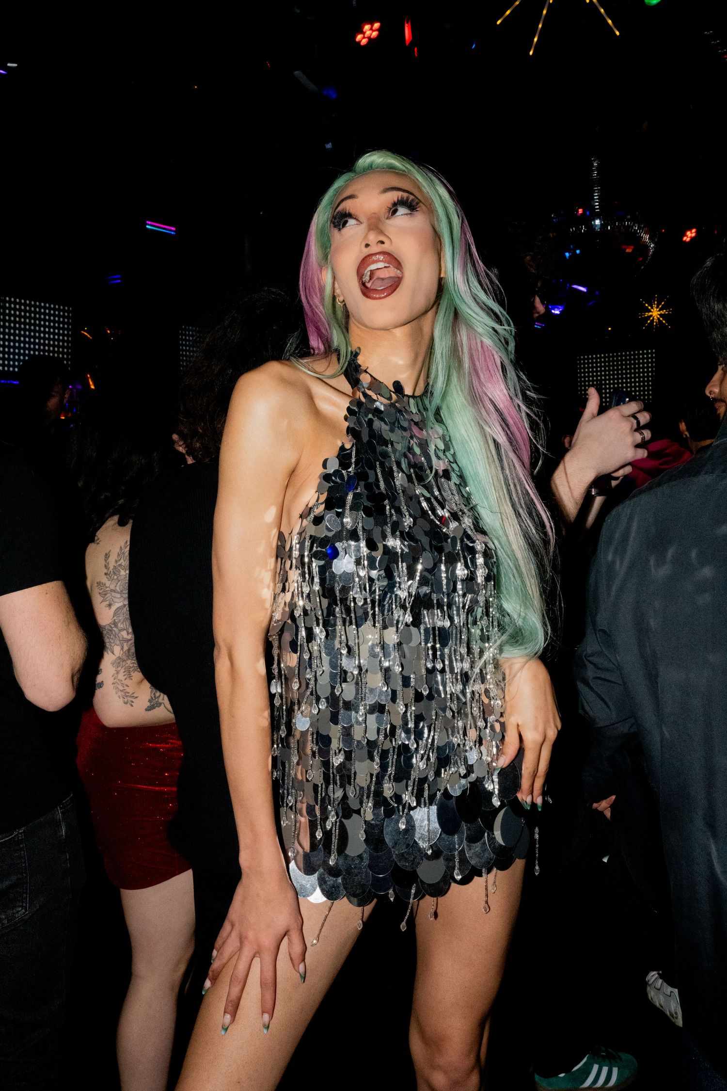 Drag Queen Kerri Colby poses in a green and purple pastel wig and disco ball dress inside Flicks, a gay nightclub in Hillcrest, San Diego